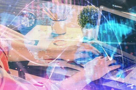Double exposure of businessman working on laptop on background. International business hologram in front. Concept of success.の写真素材