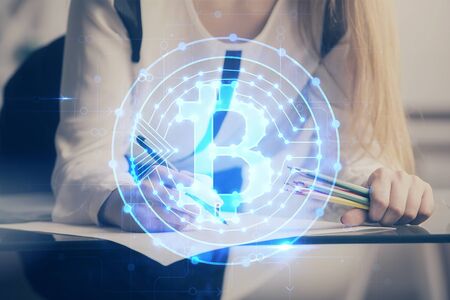 Cryptocurrency hologram over womans hands writing background. Concept of blockchain. Double exposureの写真素材