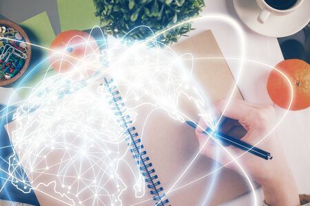 International business hologram over womans hands taking notes background. Concept of success. Double exposureの写真素材