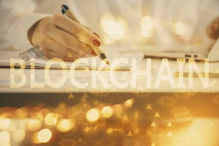 Cryptocurrency hologram over woman's hands writing background. Concept of blockchain. Double exposureの写真素材