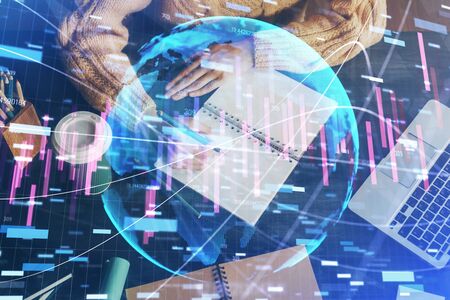 Forex graph on hand taking notes background. Concept of research. Double exposureの写真素材