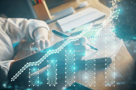 Financial forex charts displayed on woman hand taking notes background. Concept of research. Double exposureの写真素材