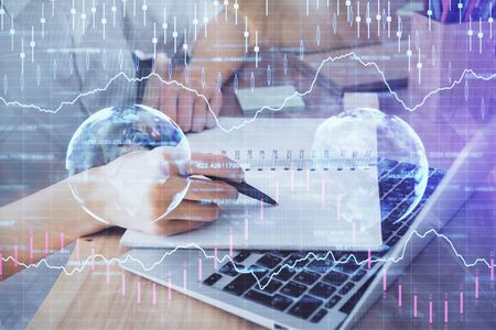 Financial charts displayed on womans hand taking notes background. Concept of research. Double exposureの写真素材