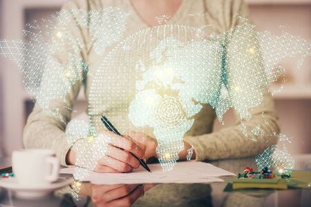 International business hologram over womans hands taking notes background. Concept of success. Double exposureの写真素材