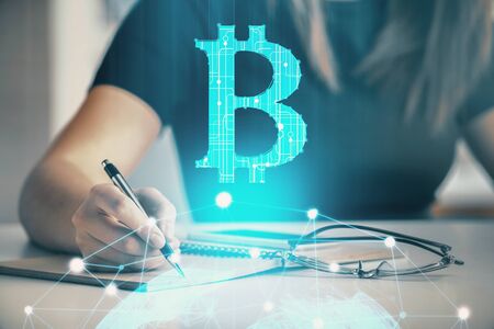 Cryptocurrency hologram over womans hands writing background. Concept of blockchain. Double exposureの写真素材