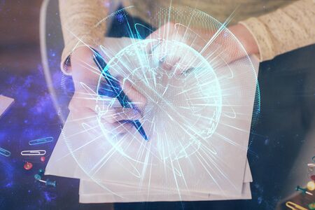 International business hologram over womans hands taking notes background. Concept of success. Double exposureの写真素材