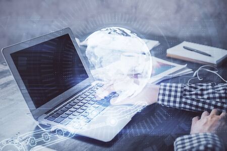 Multi exposure of world map hologram with man working on computer on background. Concept of worldwideweb.の写真素材