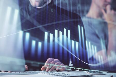 Forex graph with businessman working on computer in office on background. Concept of analysis. Double exposure.の写真素材