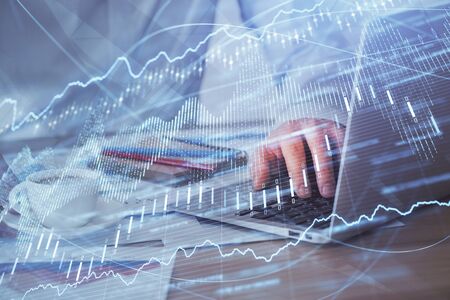 Forex graph with businessman working on computer in office on background. Concept of hardworking....