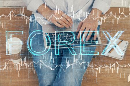 Forex graph with businessman working on computer in office on background. Concept of analysis. Double exposure.の写真素材