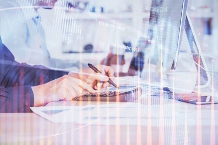 Forex graph with businessman working on computer in office on background. Concept of hardworking. Closeup. Multi exposure.の写真素材