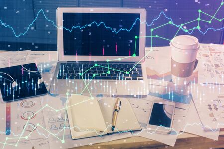 Financial graph colorful drawing and table with computer on background. Double exposure. Concept of international markets.の写真素材
