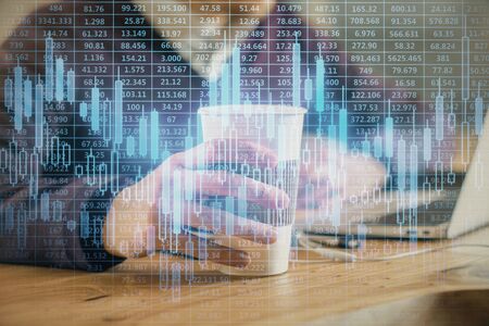 Forex graph with businessman working on computer in office on background. Concept of hardworking....