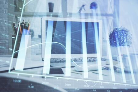 Forex graph hologram on table with computer background. Multi exposure. Concept of financial markets.の写真素材
