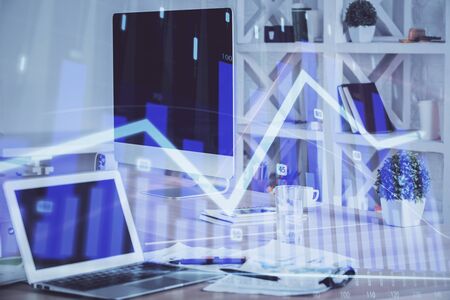 Stock market graph on background with desk and personal computer. Multi exposure. Concept of financial analysis.の写真素材