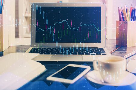 Double exposure of chart and financial info and work space with computer background. Concept of international online trading.の写真素材