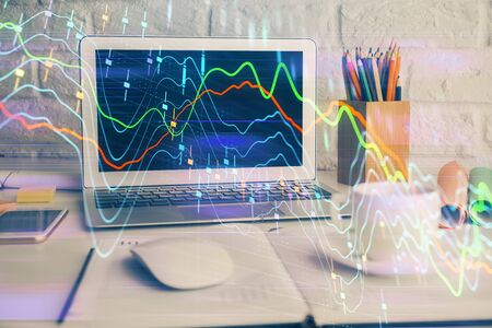 Financial market graph hologram and personal computer on background. Multi exposure. Concept of forex.の写真素材