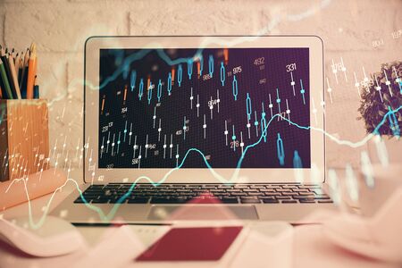 Forex market chart hologram and personal computer background. Double exposure. Concept of investment.の写真素材