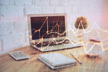 Financial graph colorful drawing and table with computer on background. Double exposure. Concept of international markets.の写真素材