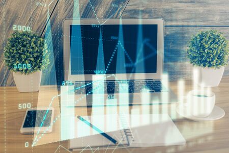 Double exposure of graph and financial info and work space with computer background. Concept of international online trading.の写真素材