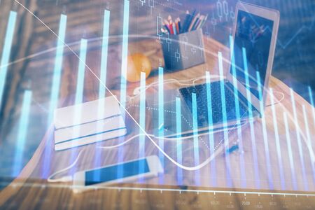 Stock market graph on background with desk and personal computer. Double exposure. Concept of financial analysis.の写真素材