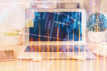 Forex market graph hologram and personal computer on background. Multi exposure. Concept of investment.の写真素材