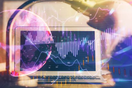Double exposure of chart and financial info and work space with computer background. Concept of international online trading.の写真素材