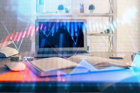 Forex market graph hologram and personal computer on background. Double exposure. Concept of investment.の写真素材