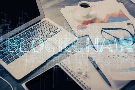 Double exposure of blockchain and crypto economy theme hologram and table with computer background....
