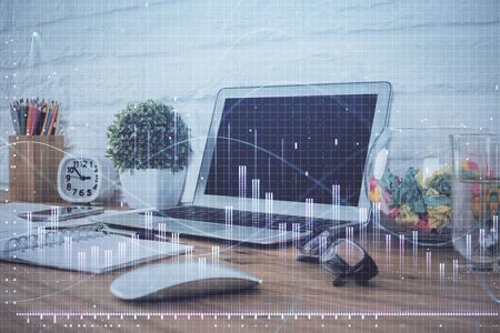 Financial graph colorful drawing and table with computer on background. Multi exposure. Concept of international markets.の写真素材