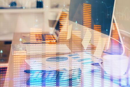 Double exposure of chart and financial info and work space with computer background. Concept of...