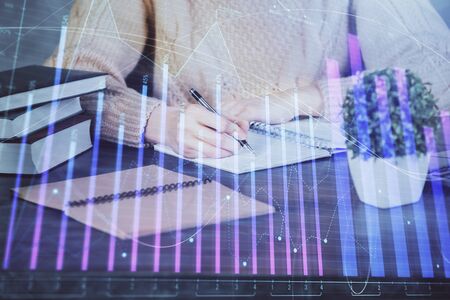 Forex graph on hand taking notes background. Concept of research. Double exposureの写真素材