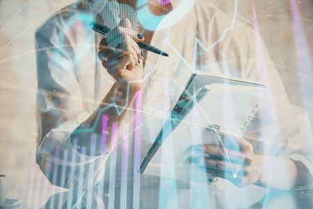 Financial chart drawn over hands taking notes background. Concept of research. Multi exposureの写真素材