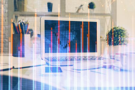 Stock market graph on background with desk and personal computer. Multi exposure. Concept of financial analysis.の写真素材
