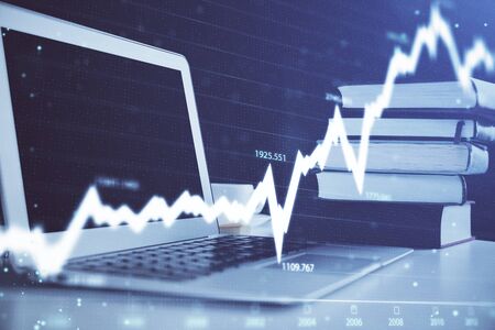 Stock market graph on background with desk and personal computer. Double exposure. Concept of...