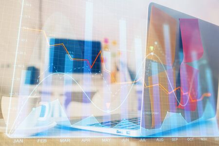 Forex market graph hologram and personal computer on background. Double exposure. Concept of investment.の写真素材