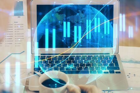 Financial market graph hologram and personal computer on background. Multi exposure. Concept of forex.の写真素材