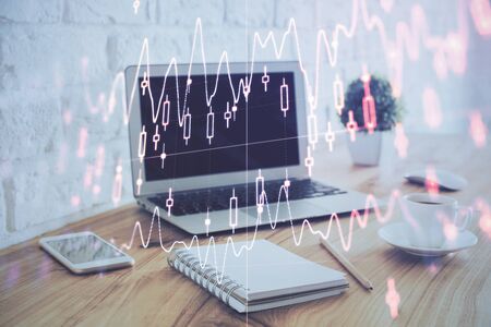 Stock market chart hologram drawn on personal computer background. Multi exposure. Concept of investment.の写真素材