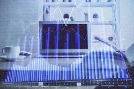 Financial chart drawing and table with computer on background. Multi exposure. Concept of international markets.の写真素材