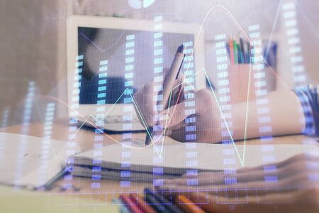 Financial forex charts displayed on womans hand taking notes background. Concept of research. Double exposureの写真素材