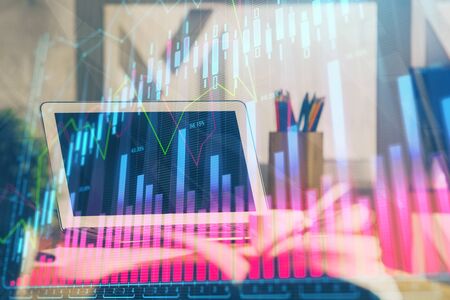 Financial graph colorful drawing and table with computer on background. Double exposure. Concept of international markets.の写真素材