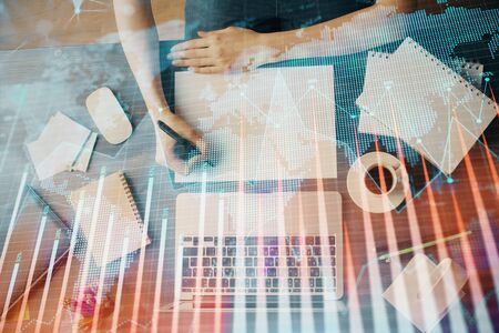 Financial graph displayed on woman's hand taking notes background. Concept of research. Multi exposureの写真素材