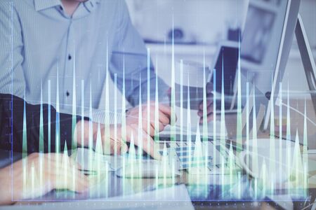 Multi exposure of chart with man typing on computer in office on background. Concept of hard work.