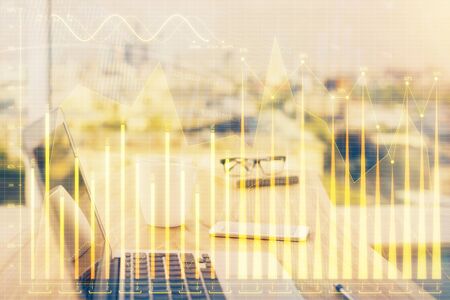 Stock market graph on background with desk and personal computer. Multi exposure. Concept of financial analysis.の写真素材