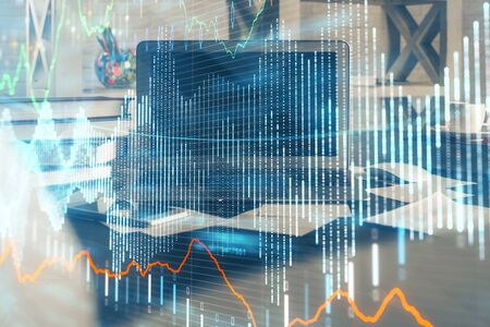 Financial graph colorful drawing and table with computer on background. Multi exposure. Concept of international markets.の写真素材