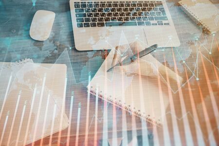 Financial graph displayed on woman's hand taking notes background. Concept of research. Multi exposureの写真素材