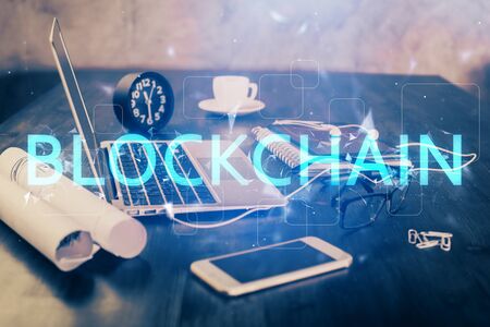Double exposure of blockchain and crypto economy theme hologram and table with computer background....