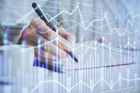 Forex chart displayed on womans hand taking notes background. Concept of research. Double exposureの写真素材