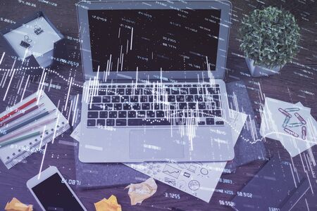 Financial graph colorful drawing and table with computer on background. Double exposure. Concept of international markets.の写真素材