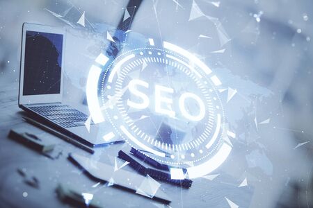 Double exposure of table with computer and seo drawing hologram. Search optimization concept.の写真素材